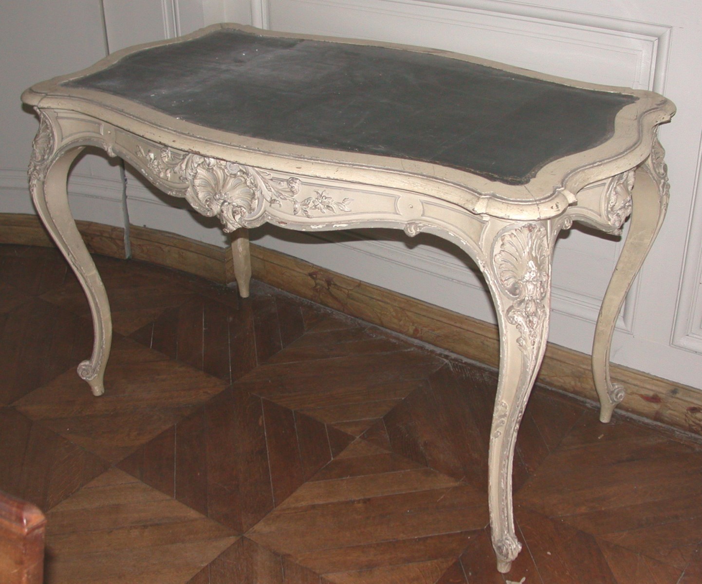 Une table sculptée de style Louis XV peinte en gris laqué