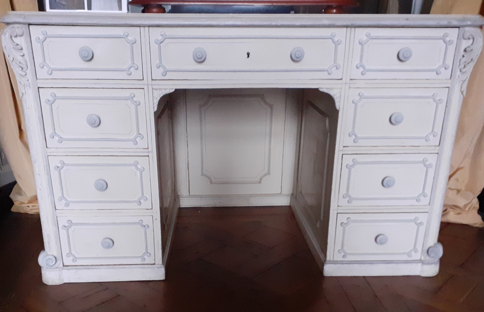 Une table bureau à neuf tiroirs peinte en gris laqué