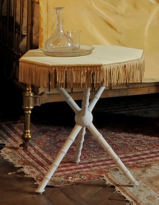 Guéridon octogona àl trois pieds peint en gris et recouvert de reps de soie jaune à franges et passementerie