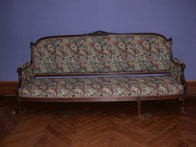 Grand canapé en bois sculpté avec filets métalliques recouvert d'un tissu mille feuilles à fond vert