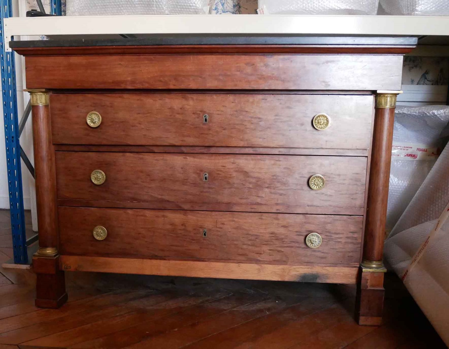 Commode à colonnettes recouverte de marbre noir, trois tiroirs avec boutons en bronze doré