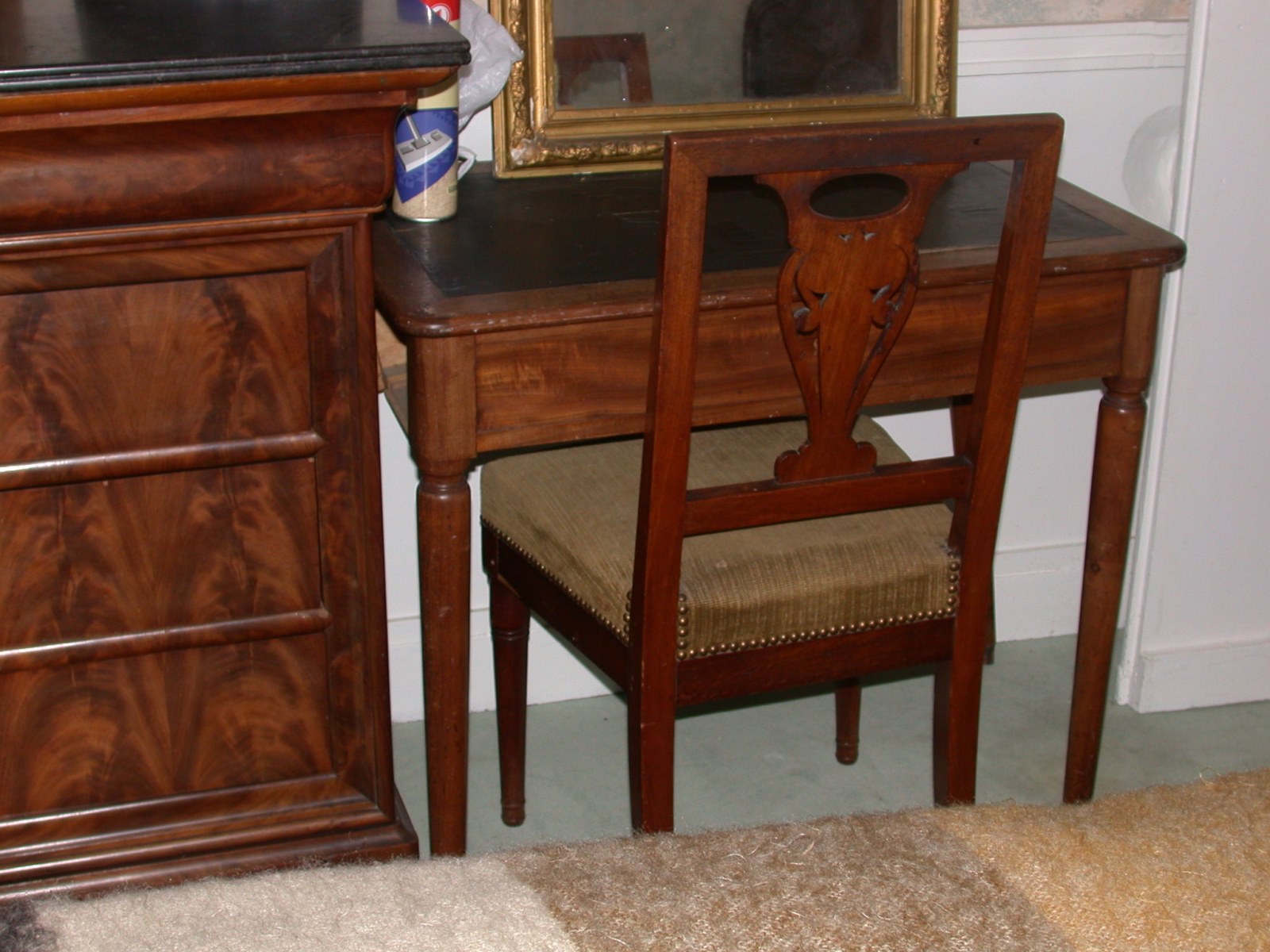 Table en acajou clair à pieds ronds recouverte de cuir noir, un tiroir devant et un sur le côté