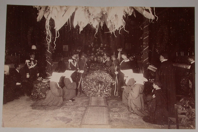 Cercueil du duc d’Aumale recouvert de fleurs, avec quatre religieuses agenouillées au premier plan, Sicile, mai 1897 ; Album relié de cuir vert, contenant 12 photographies anonymes, inscription en lettres d’or : SICILE / 1897