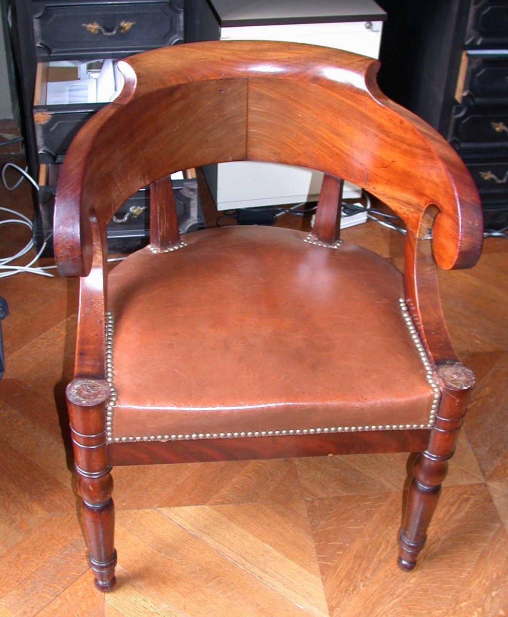 Fauteuil de bureau en acajou garni de cuir à bras en volutes