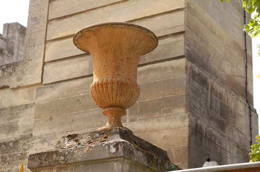 Vase en fonte posé sur le haut du pilastre