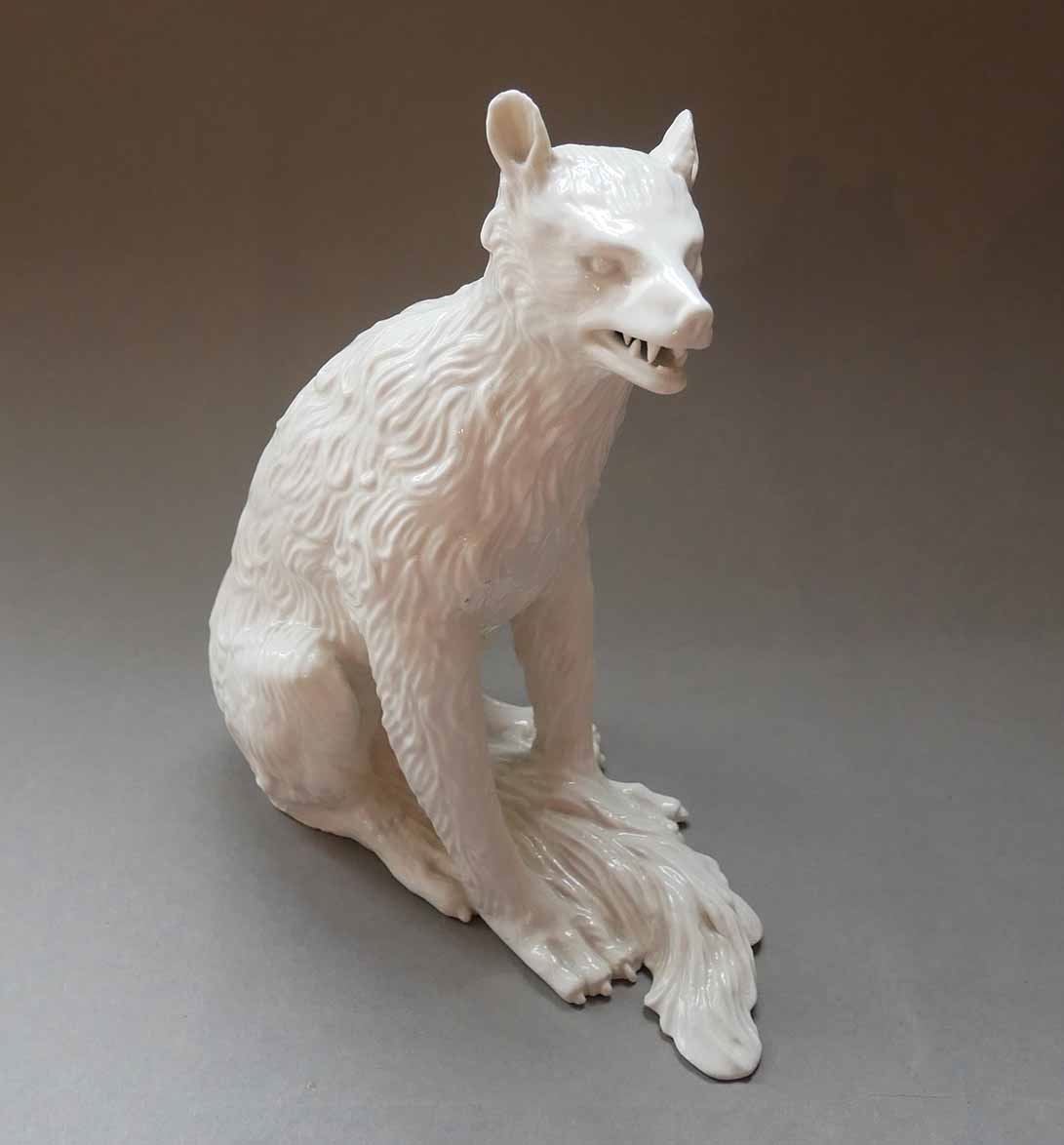 Statuette à émail stannifère représentant un loup aux aguets assis