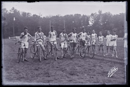 Groupe de scouts arméniens en tenue de sport posant avec bicyclette (titre factice)