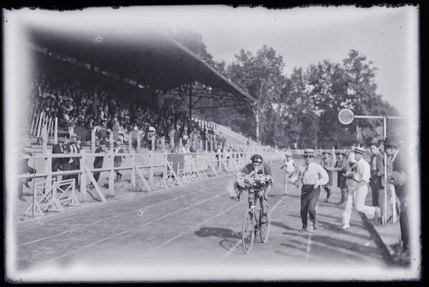 Sebouh Madroyan de la section de Marseille de l'Union générale arménienne de culture physique et de scoutisme franchissant la ligne d'arrivée de la course cycliste des 3èmes Olympiades (titre factice) ; 3èmes Olympiades du 9 août 1925 à Paris au stade de la Porte Dorée