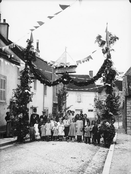 Rue décorée. Enfants et adultes sous un arc de triomphe R.F. (titre usuel)