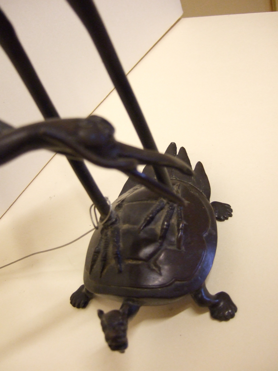 Candélabre en forme de grue debout sur une tortue-serpent. (2/2). (titre factice)