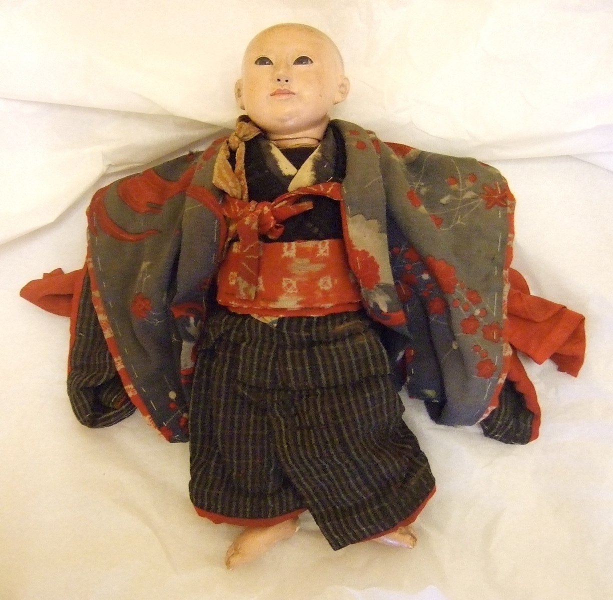 Poupée japonaise en kimono rouge et gris. (titre factice)