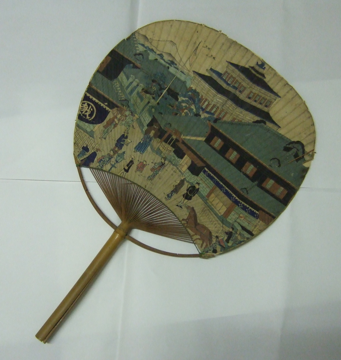 Eventail japonais avec une ville d'un côté et un char avec fleur de l'autre, en décor. (titre factice)
