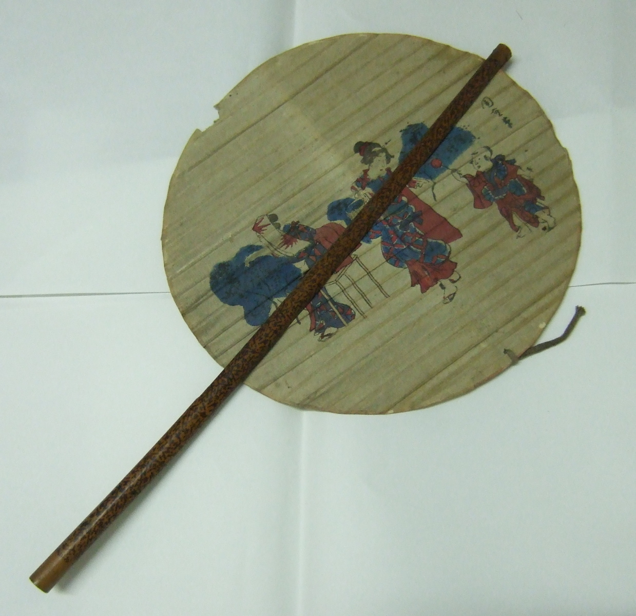 Eventail japonais rond avec un décor de deux femmes à la cueillette et un enfant tenant une sucette. (titre factice)