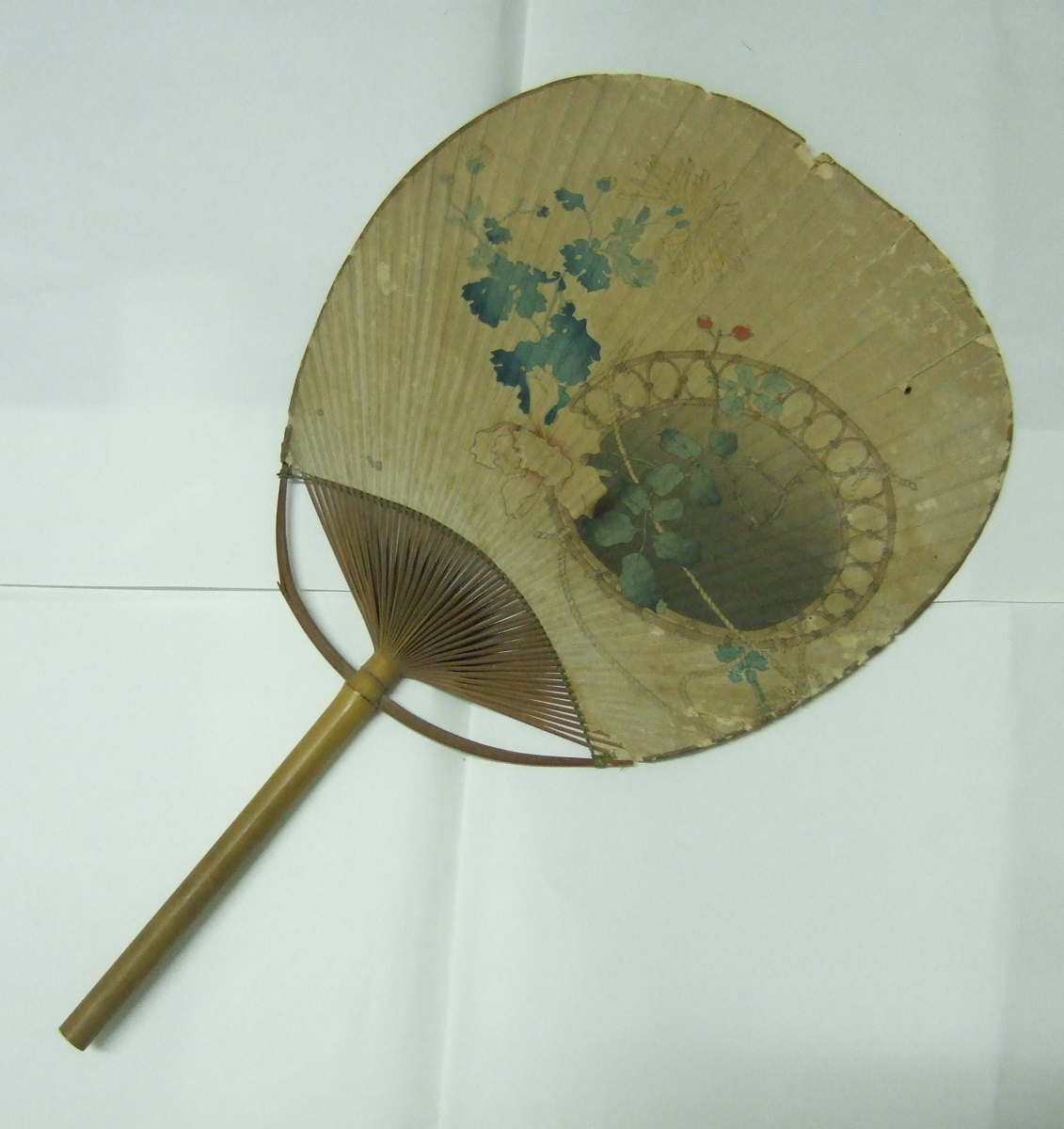 Eventail japonais carré avec un fauteuil en osier et fleurs pour décor. (titre factice)