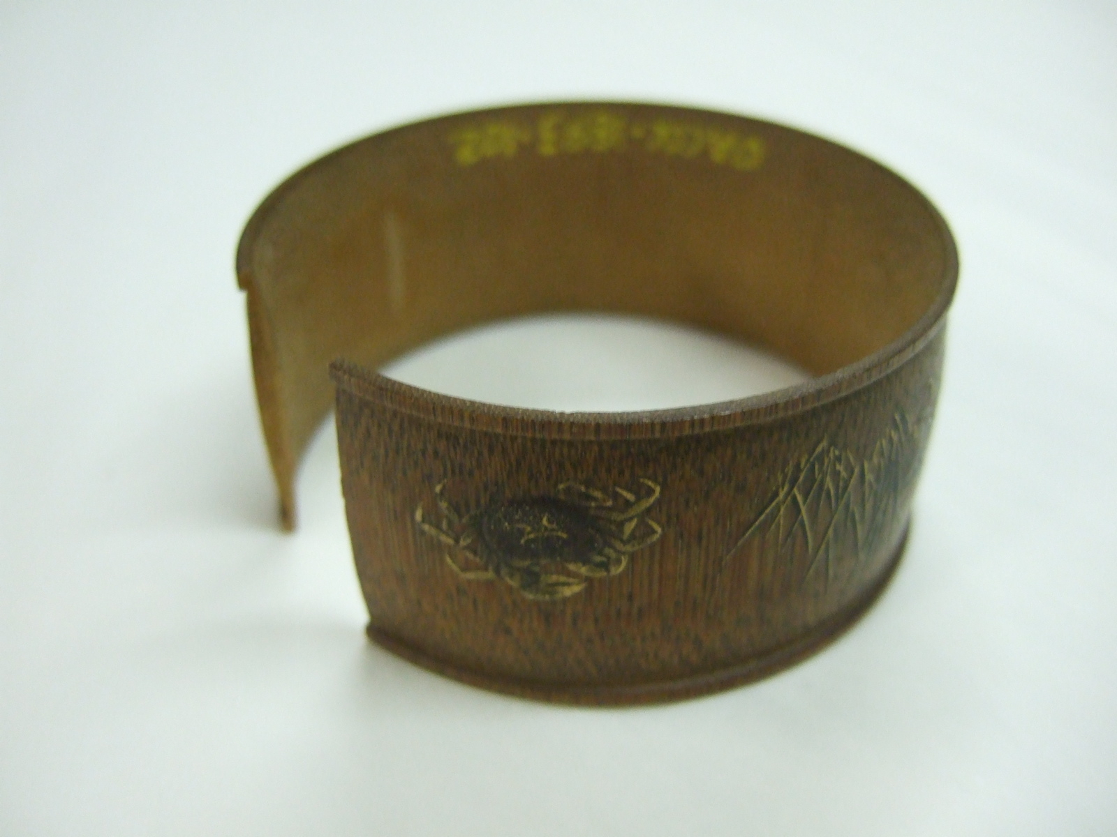 Rond de serviette asiatique en bambou, motif de crabes, herbe et fleurs. (titre factice)