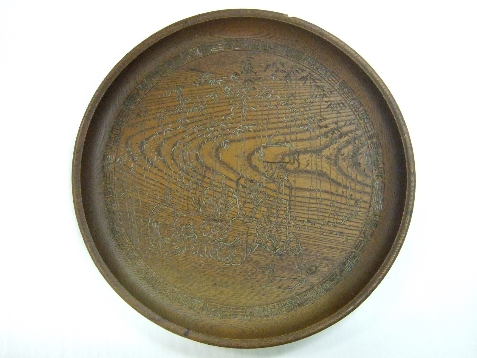 Plat rond asiatique en bois avec personnages et bambous sculptés. (titre factice)