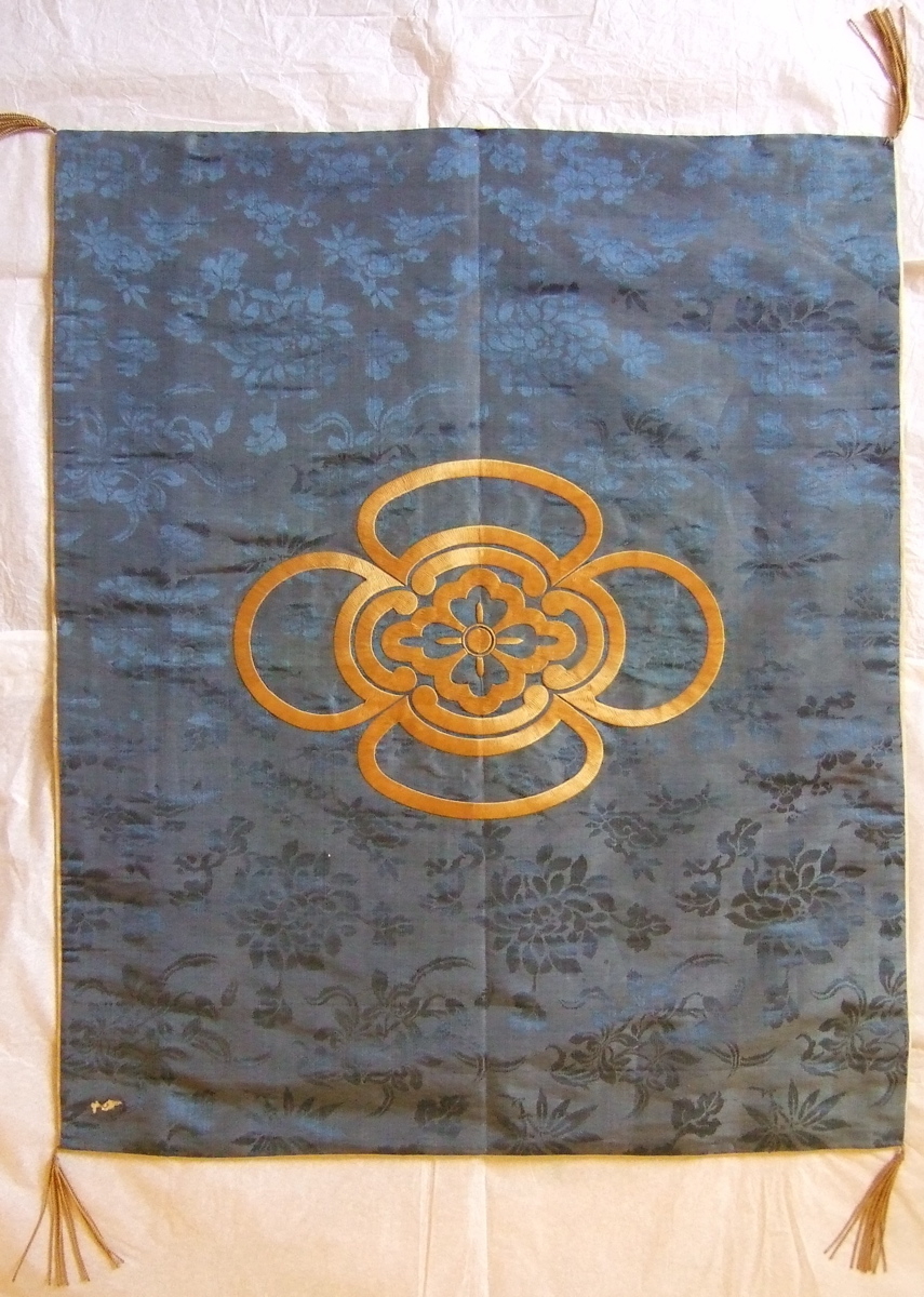 Foukousa brodé d'une rosace dorée sur fond bleu. Doublure beige brodée d'une autre rosace. 4 gland dans les angles. (titre factice)