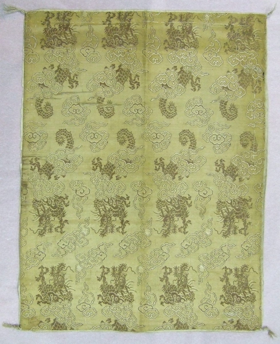 Tissu brodé de motifs répétés de dragons et nuages sur fond doré, doublure beige avec motifs dans la trame. (titre factice)