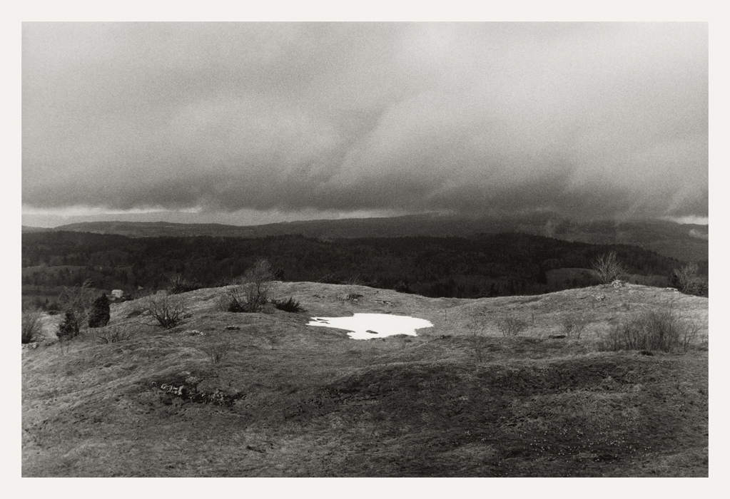 Au-dessus des Bouchoux, 2009 : au premier plan, effet de lumière sur une plaque de neige et en arrière-plan, vue sur les monts du Jura