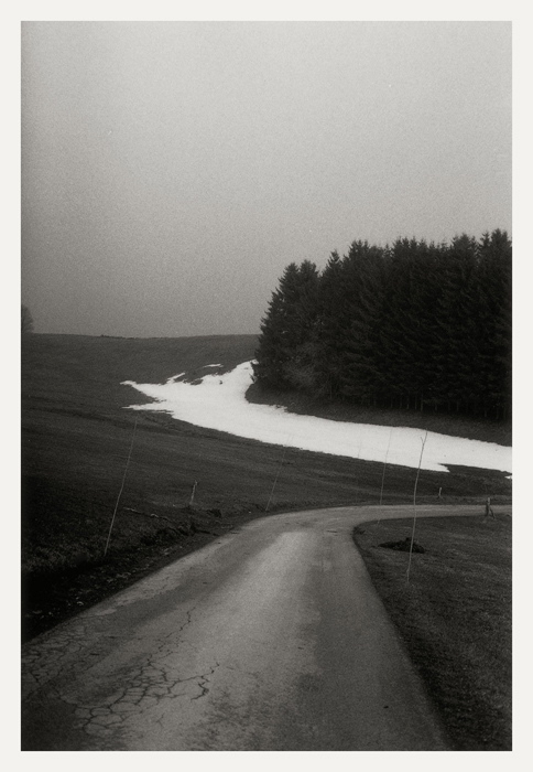 Près de Châtelblanc 2009, petite route tournant sur la droite, prairie et plaque de neige au pied de résineux