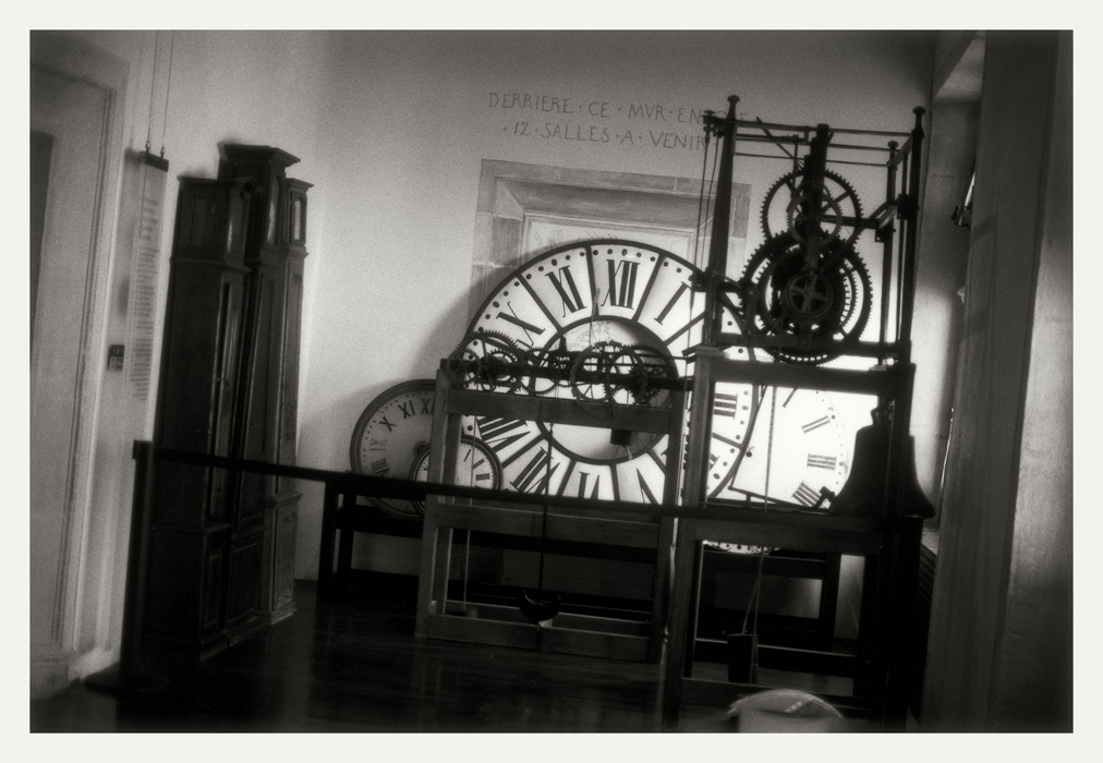 Besançon 2008, musée du Temps, premier étage. Contre un mur, cadrans de grandes dimensions ; à gauche, horloges de parquet et à droite, mécanisme d'horloge d'édifice