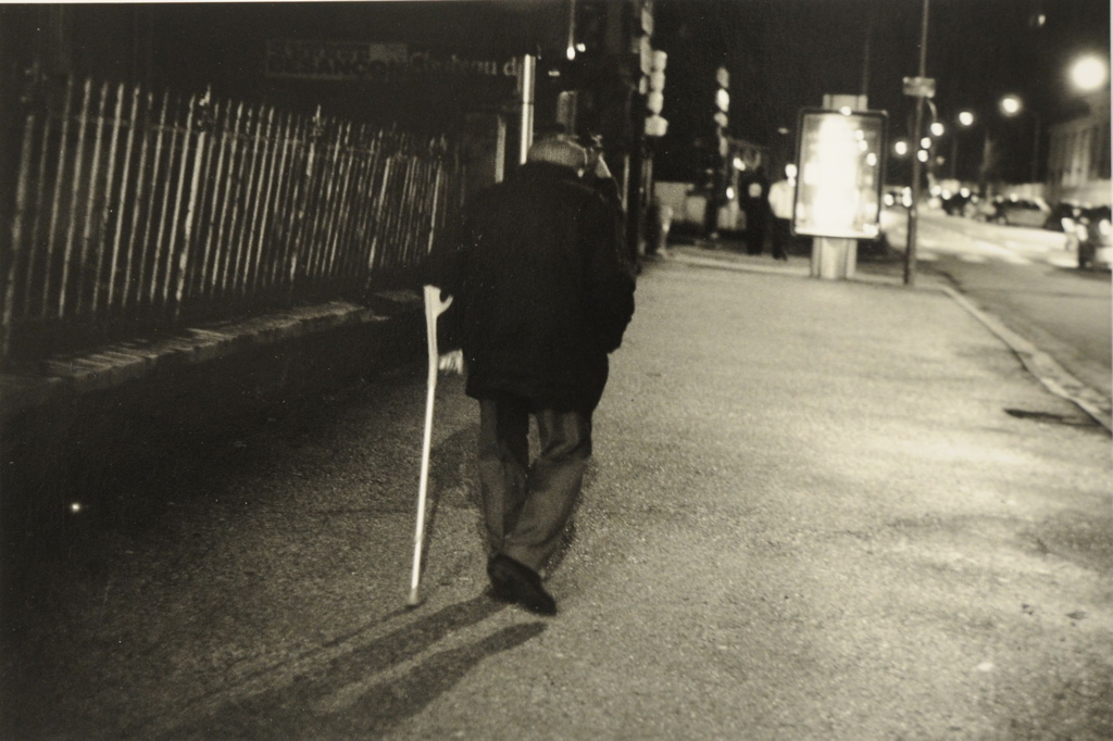 Pontarlier 2008,  vue d'une rue  la nuit. Vieillard vu de dos s'appuyant sur une béquille