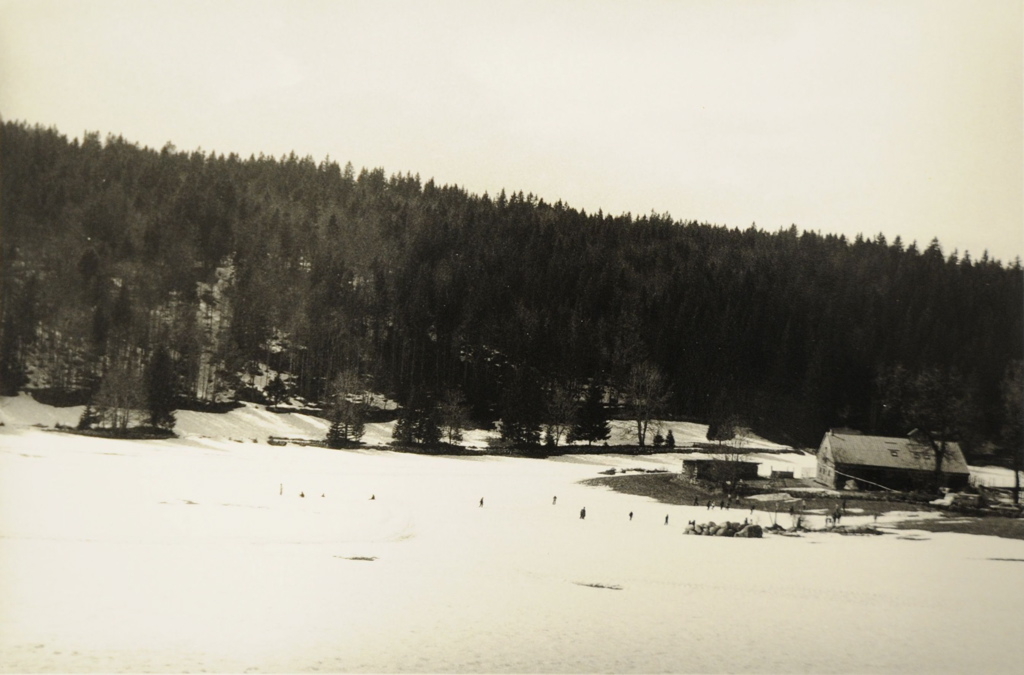 Paysage près de Chapelle-des-Bois 2009, ferme dans une grande prairie encore enneigée. Contraste entre la neige et le sombre versant  boisé à l'arrière-plan