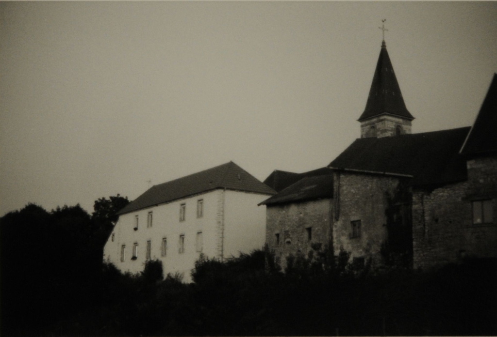 Vaire-Arcier 2008. Au premier plan à gauche, grande bâtisse blanche, à droite, maisons en pierres et à l'arrière-plan, clocher de l'église