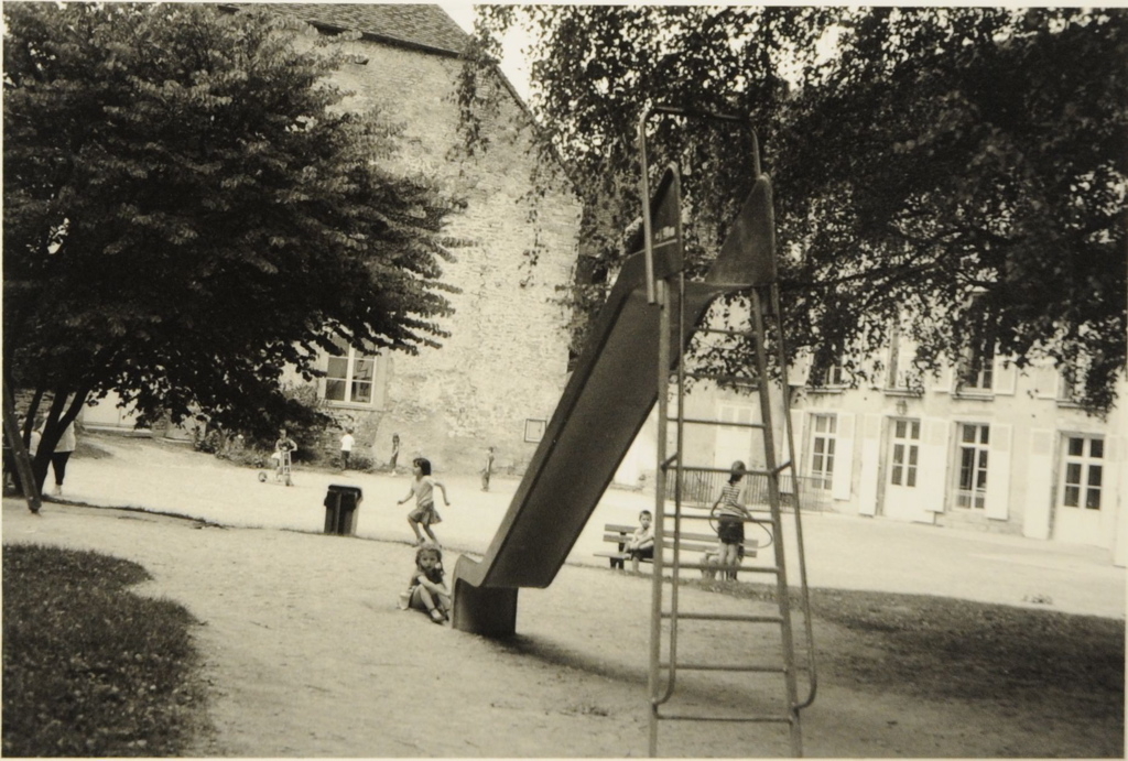 Arbois 2008. Au premier plan, toboggan dans une cour avec enfants occupés à jouer