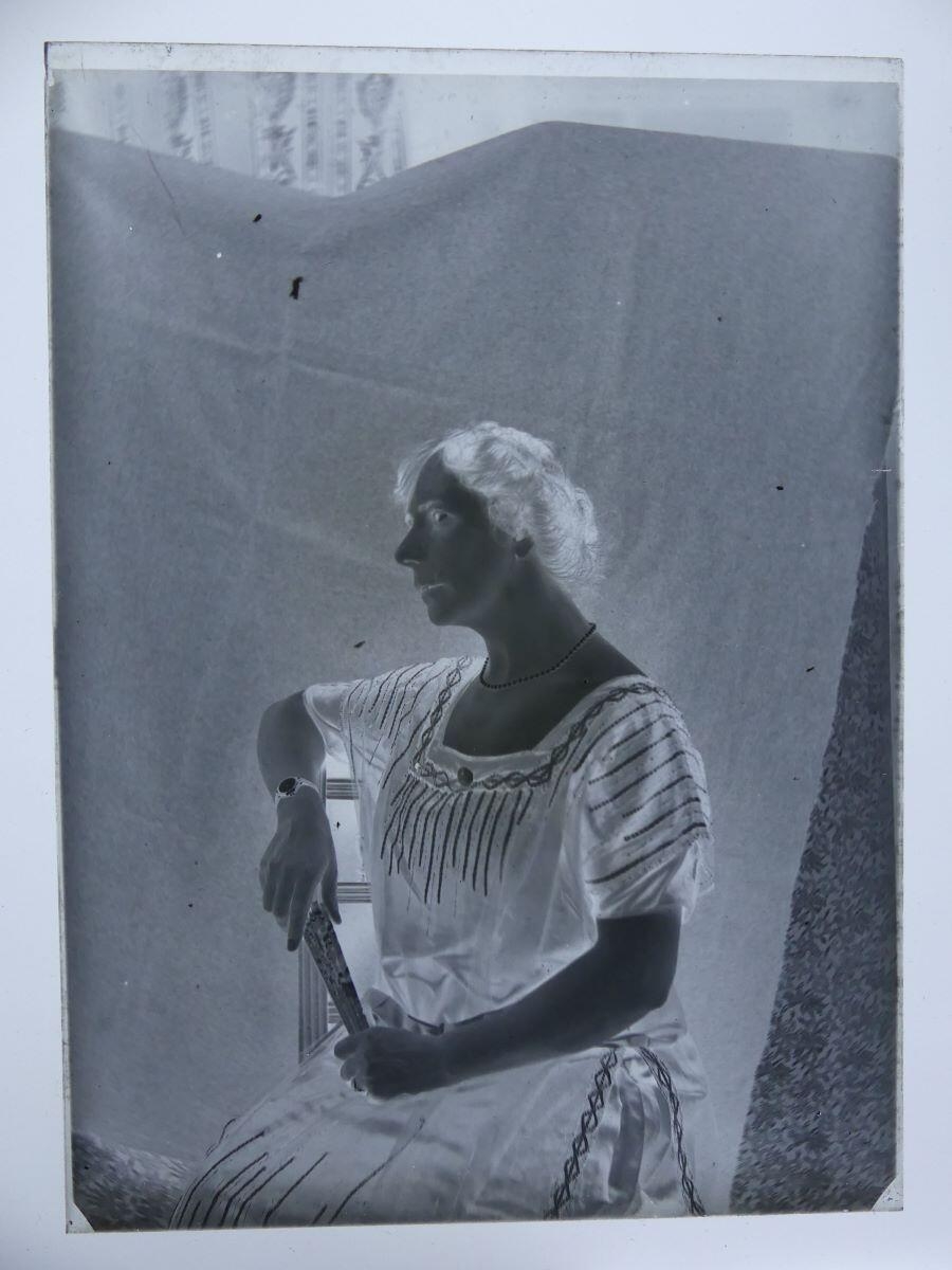 Portrait de femme assise, vue en buste, de trois quart, tenant un éventail fermé