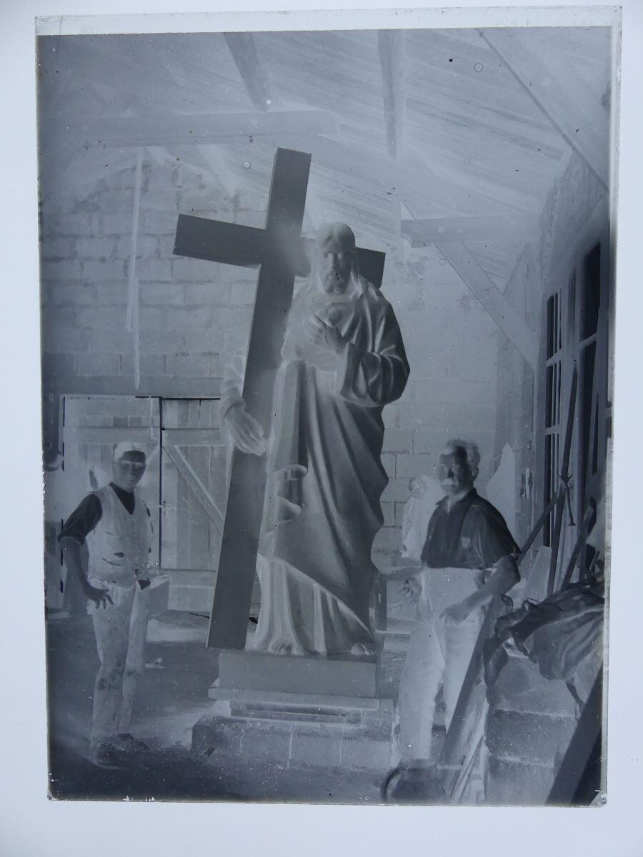 Deux praticiens de Louis Hertig posant dans un atelier autour du Christ portant la Croix du monument aux morts de Trévillers