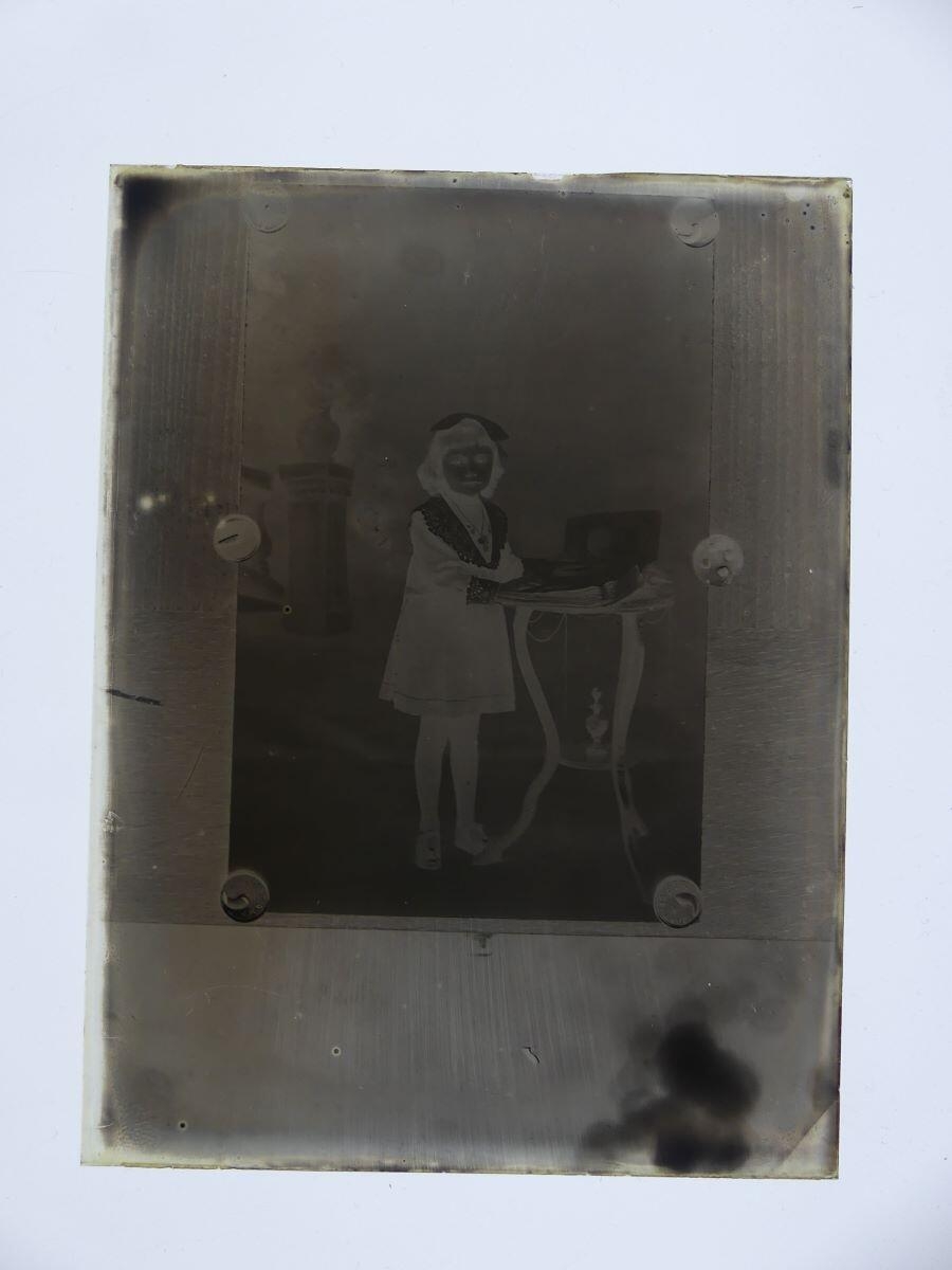 Portrait photographique d'une fillette punaisé sur une planche de bois
