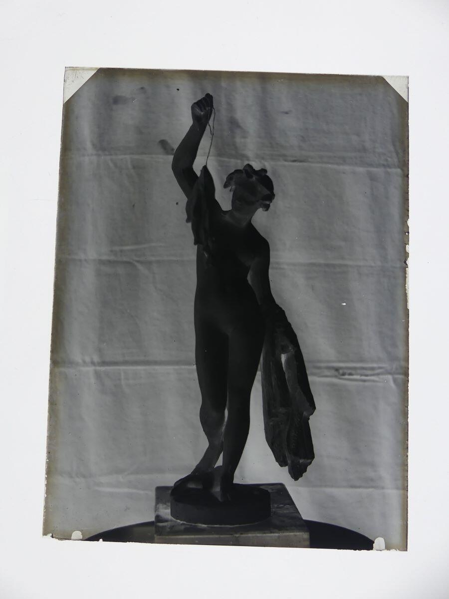 Sculpture d'un nu féminin le bras gauche levé tenant des poissons, photographié dans l'atelier