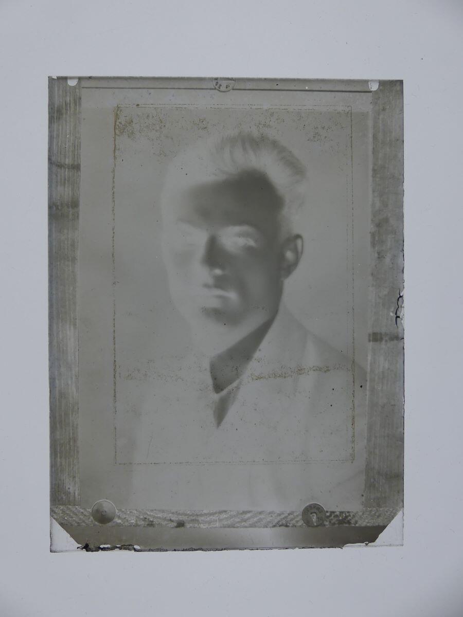 Photographie de James Hertig jeune homme punaisée sur une planche de bois