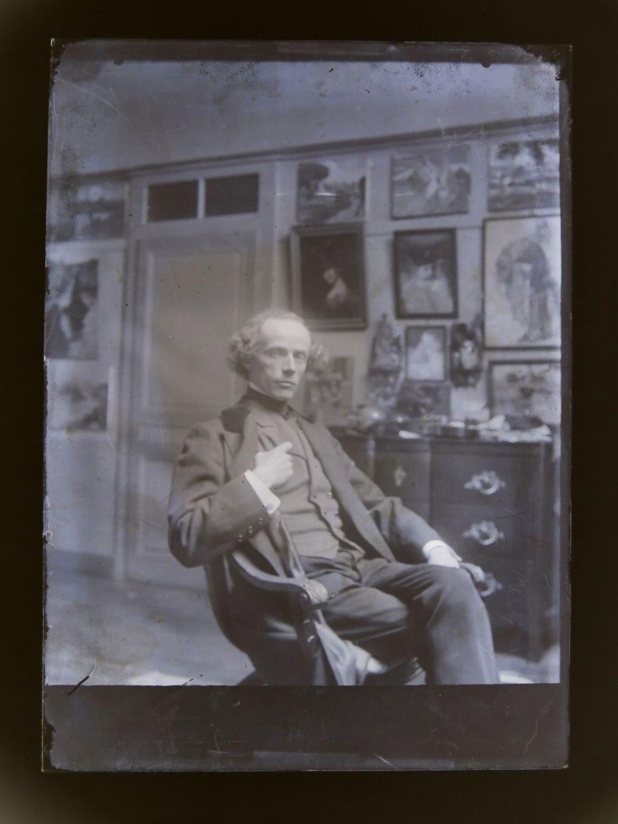 Portrait d'homme posant dans un fauteuil dans l'atelier du peintre Léon Tirode