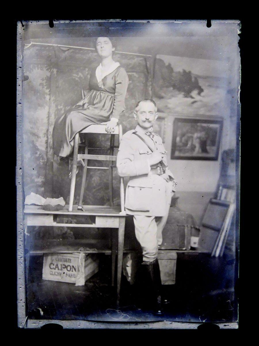 Portrait d'un homme en costume militaire et d'une femme assise posant dans l'atelier du peintre Léon Tirode