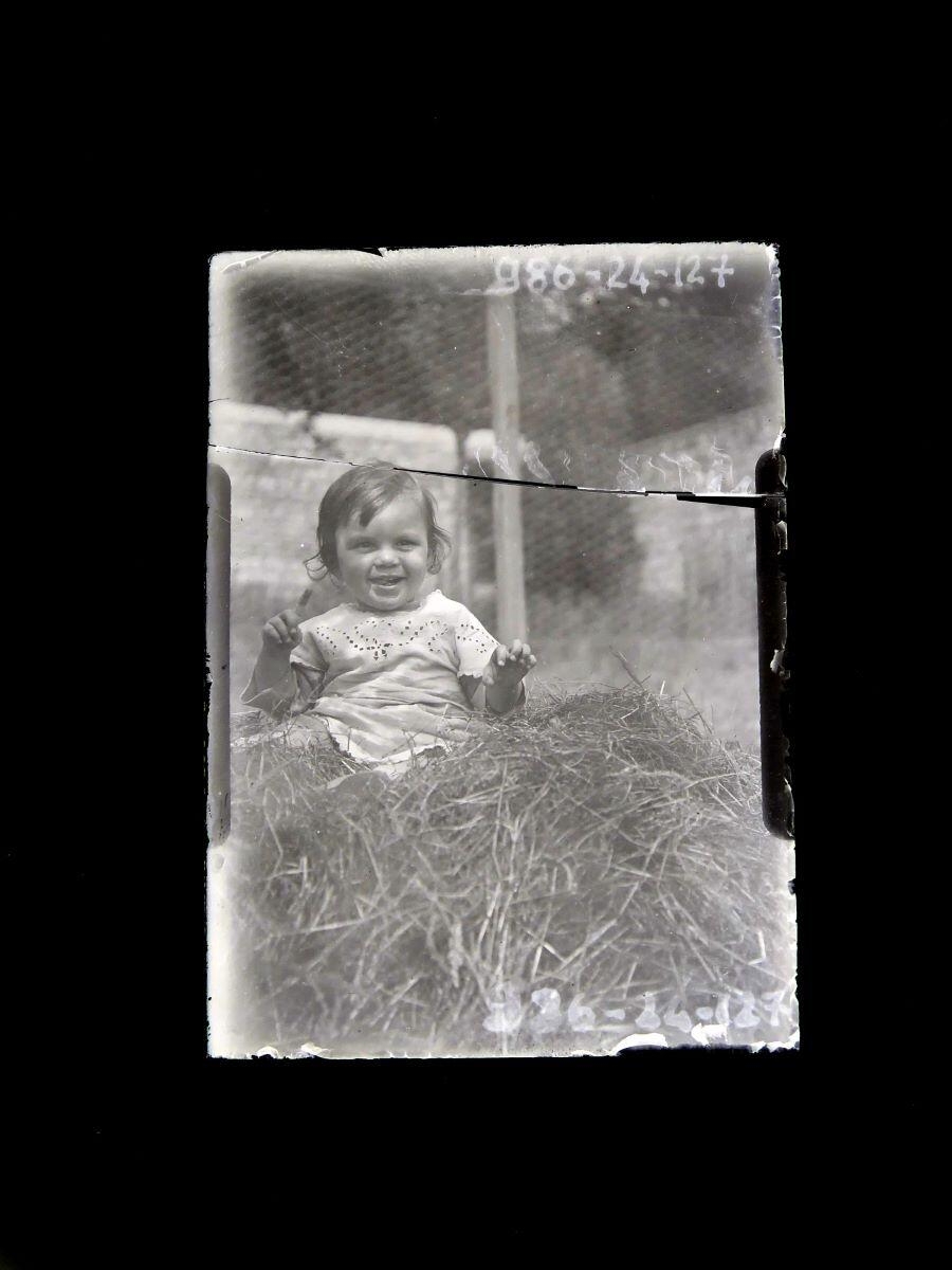 Portrait d'enfant souriant assis dans la paille