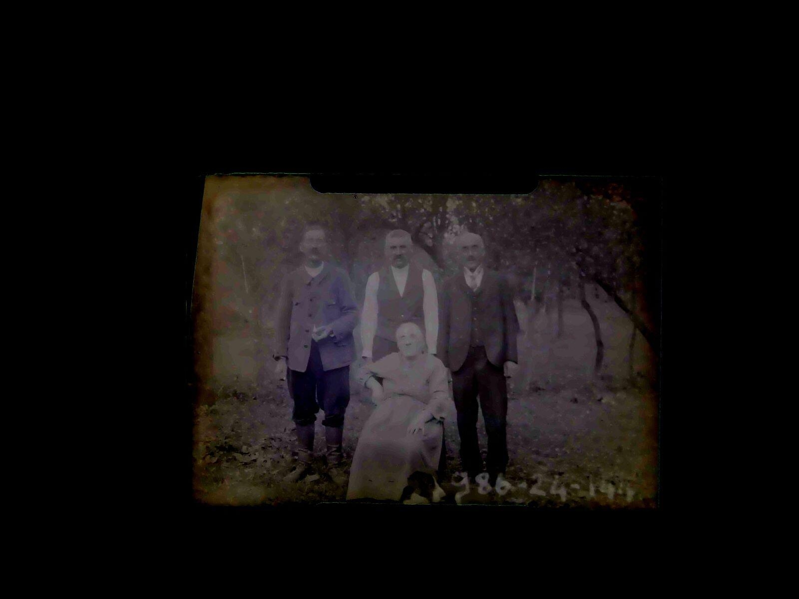 Portrait d'une femme et de trois hommes âgés posant dans un jardin
