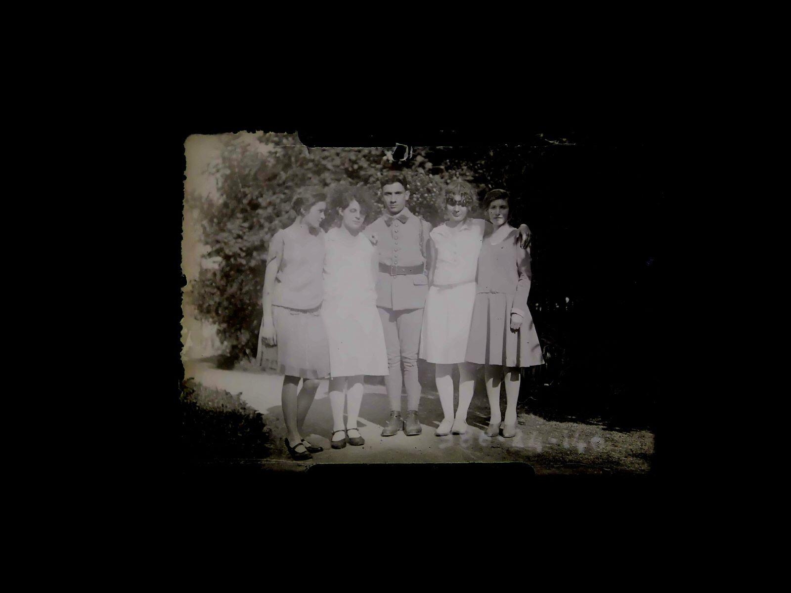 Portrait de groupe : quatre jeunes femmes entourant un jeune homme en habit militaire