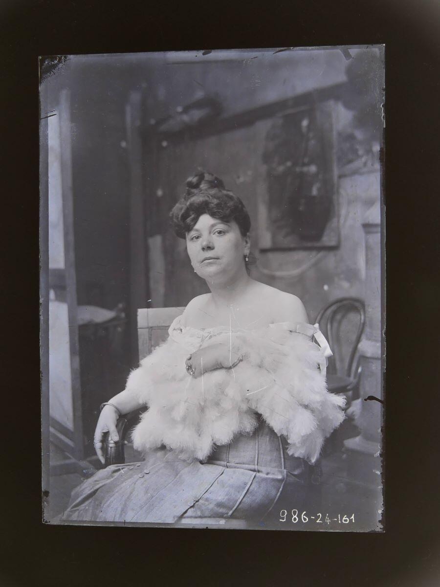 Portrait d'une femme assise dans l'atelier, les épaules nues entourées d'une étole de fourrure