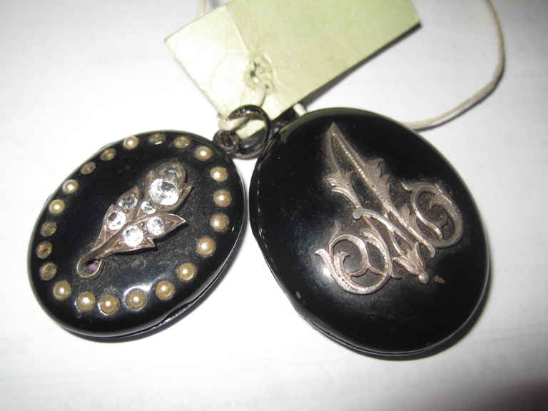Deux médaillons émaillés noirs avec fleur et initiale