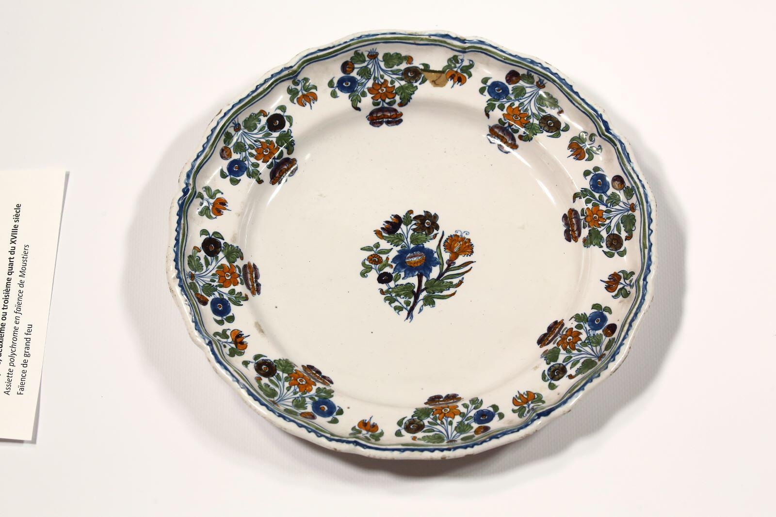 Deux assiettes polychromes en faïence de Moustiers, modèle "à la fleur de Solanée"