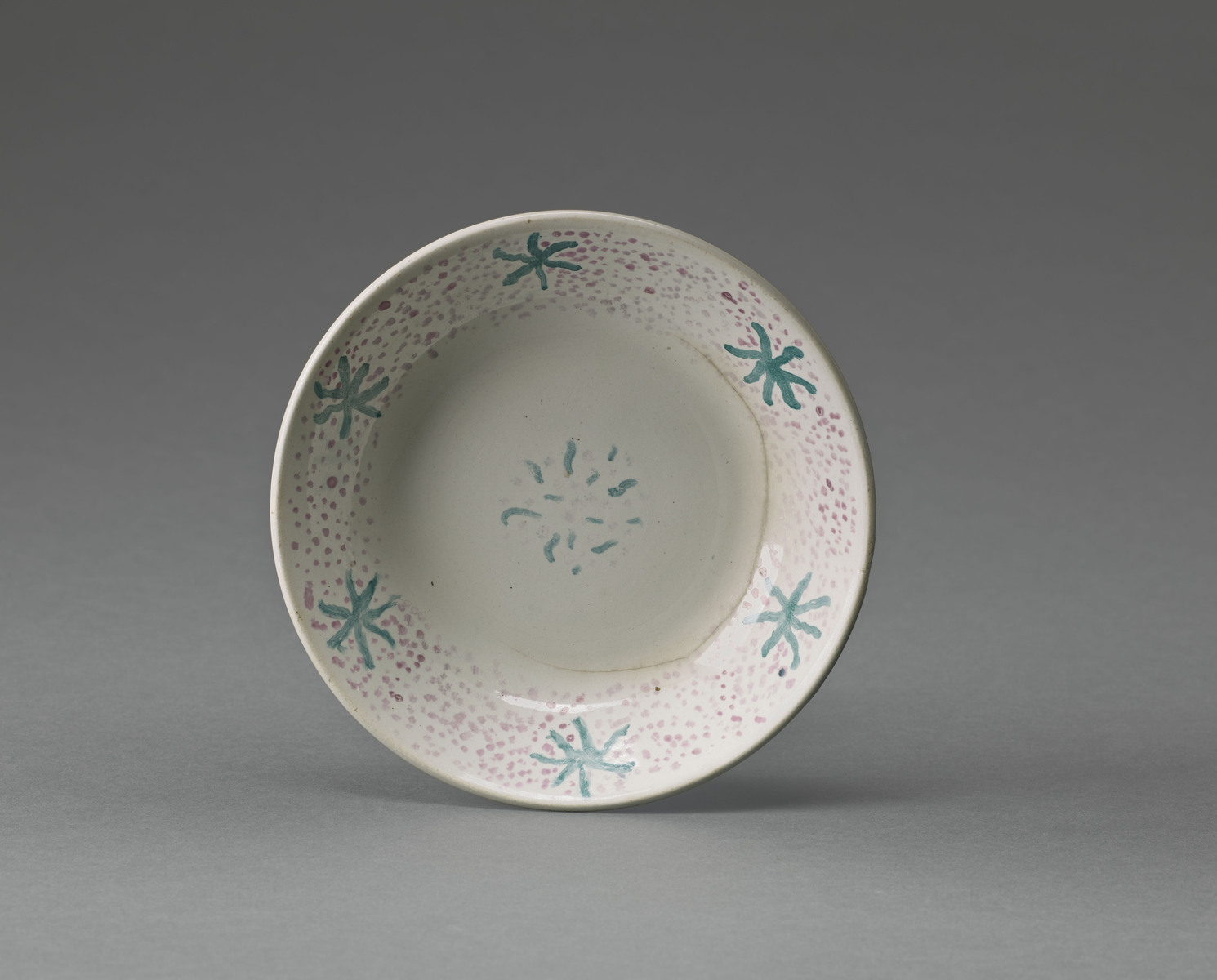 Assiette creuse à motifs abstraits vert et pointillé rouge