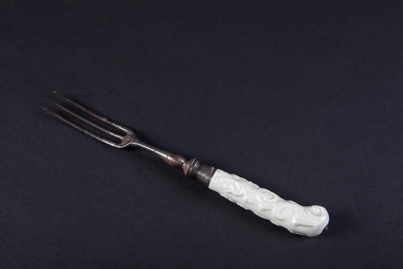 Fourchette à trois dents, manche en crosse, blanc à décor en relief