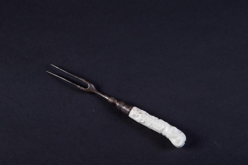 Fourchette à deux dents, manche en crosse, blanc à décor en relief