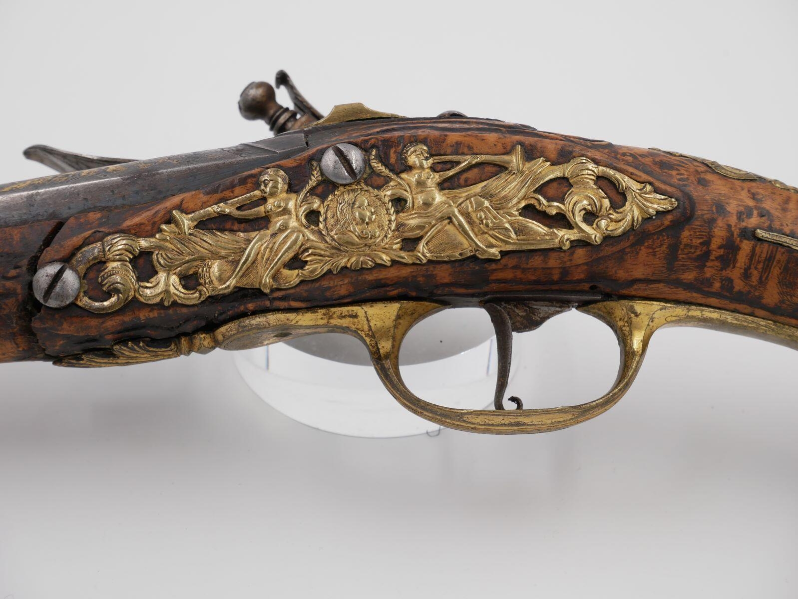 Un Pistolet à pierre - ornements en cuivre repoussé et ciselé, ornements dorés sur le canon (titre de l'inventaire)