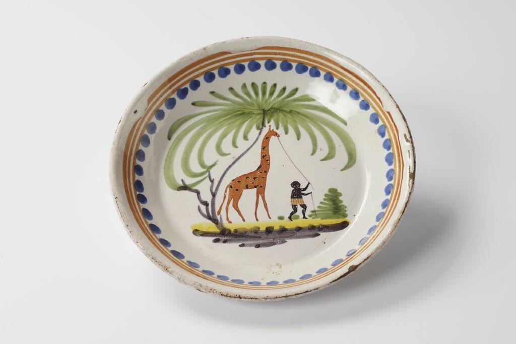 Assiette à la girafe tirée par un Noir