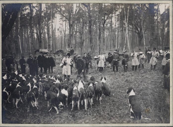 Photographie d'un album en maroquin vert comprenant 24 photographies : Equipage Par Monts et Vallons, veneur présentant la nappe aux chiens lors de la curée