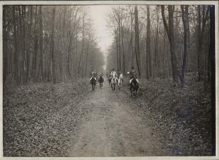 Photographie d'un album en maroquin vert comprenant 24 photographies : Equipage Par Monts et Vallons, veneurs au galop dans un chemin forestier