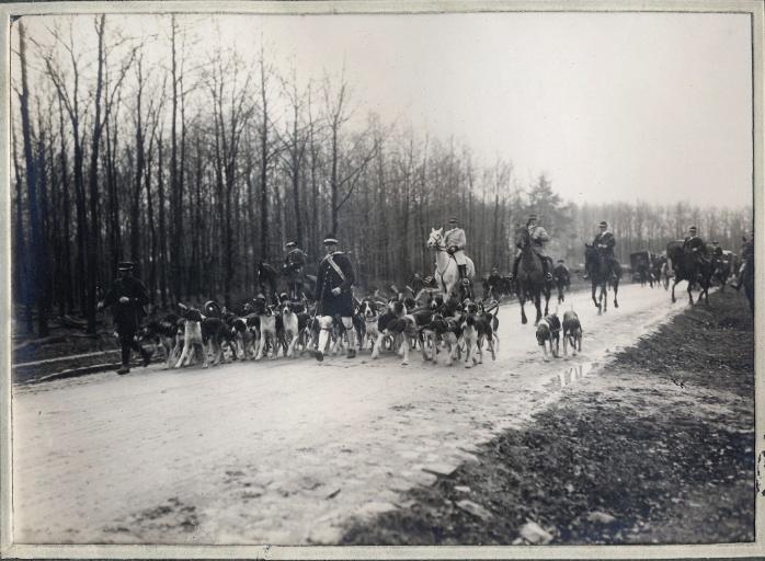 Photographie d'un album en maroquin vert comprenant 24 photographies : Equipage Par Monts et Vallons, valet de chiens et meute dans un chemin
